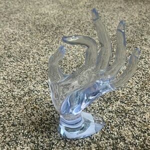 clear ring holder in the shape of a hand. it can hold a lot of rings.